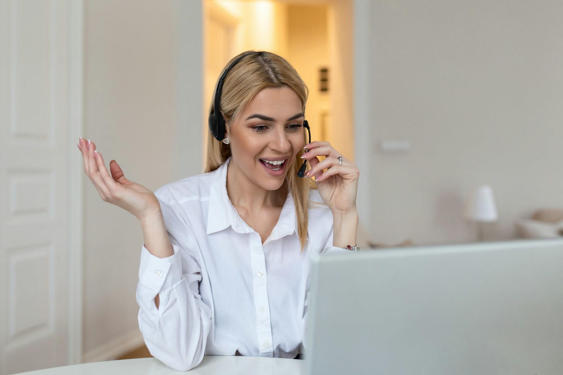 A girl wearing a headset in front of the computer.