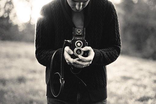 A photography teacher holding a camera