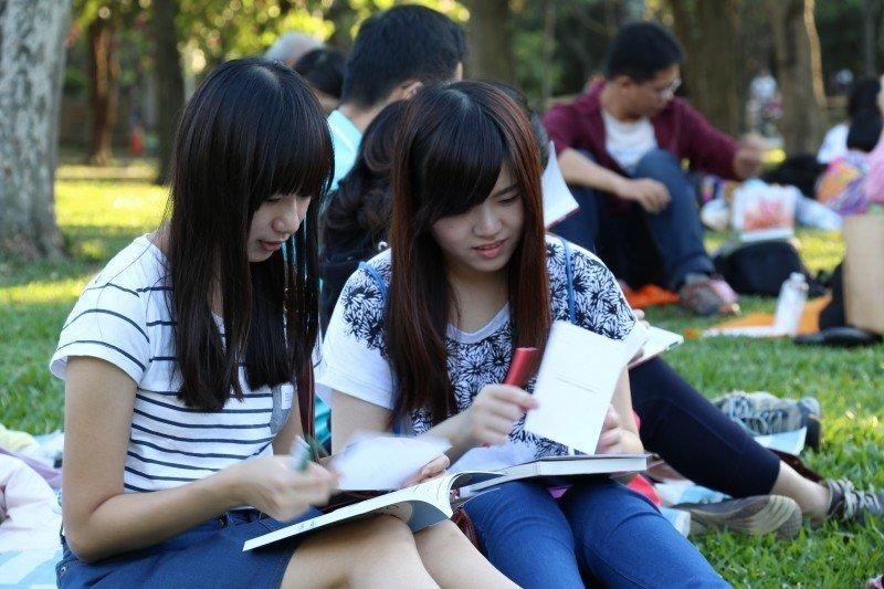 A student and her teacher study in the park.