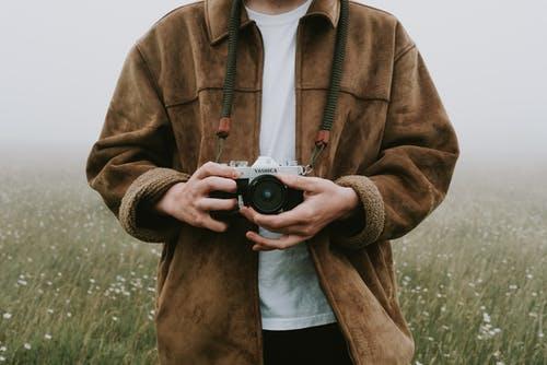 A photographer holding a camera in an outdoor photography lesson