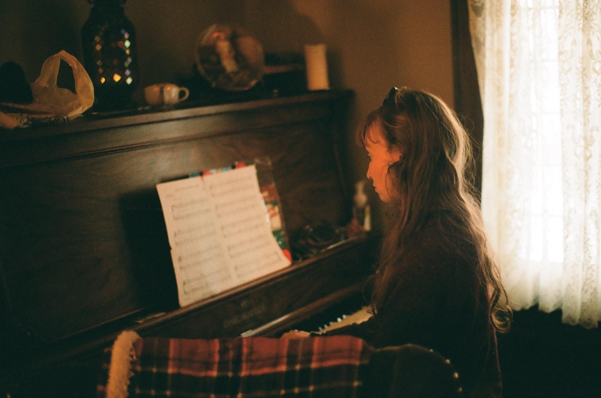 women sitting next to a piano in soft lighting