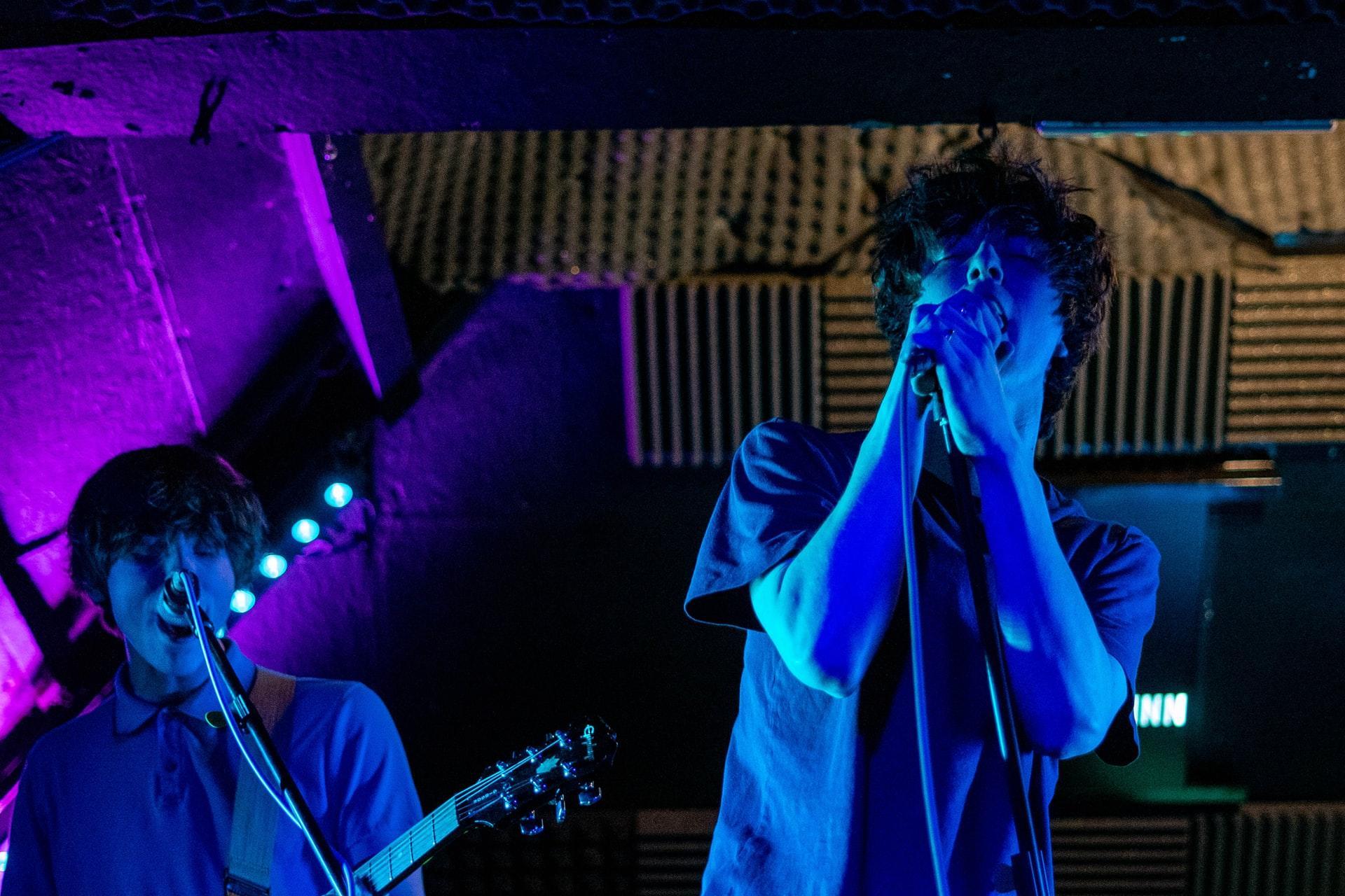 boy singing under colorful lights