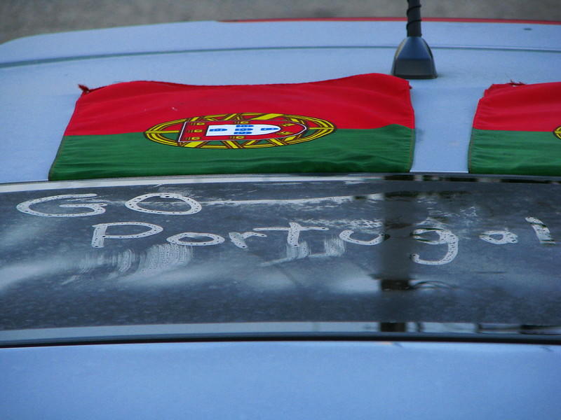 A Portuguese flag rests upon the pavement.