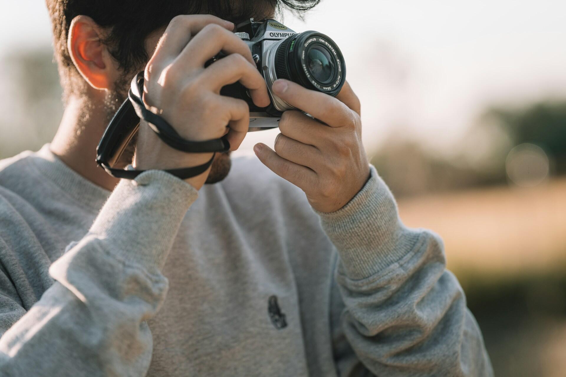 A young man using a camera.