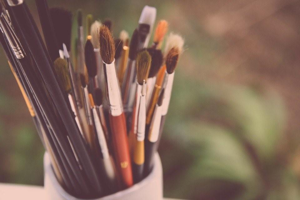 A variety of paintbrushes in a holder