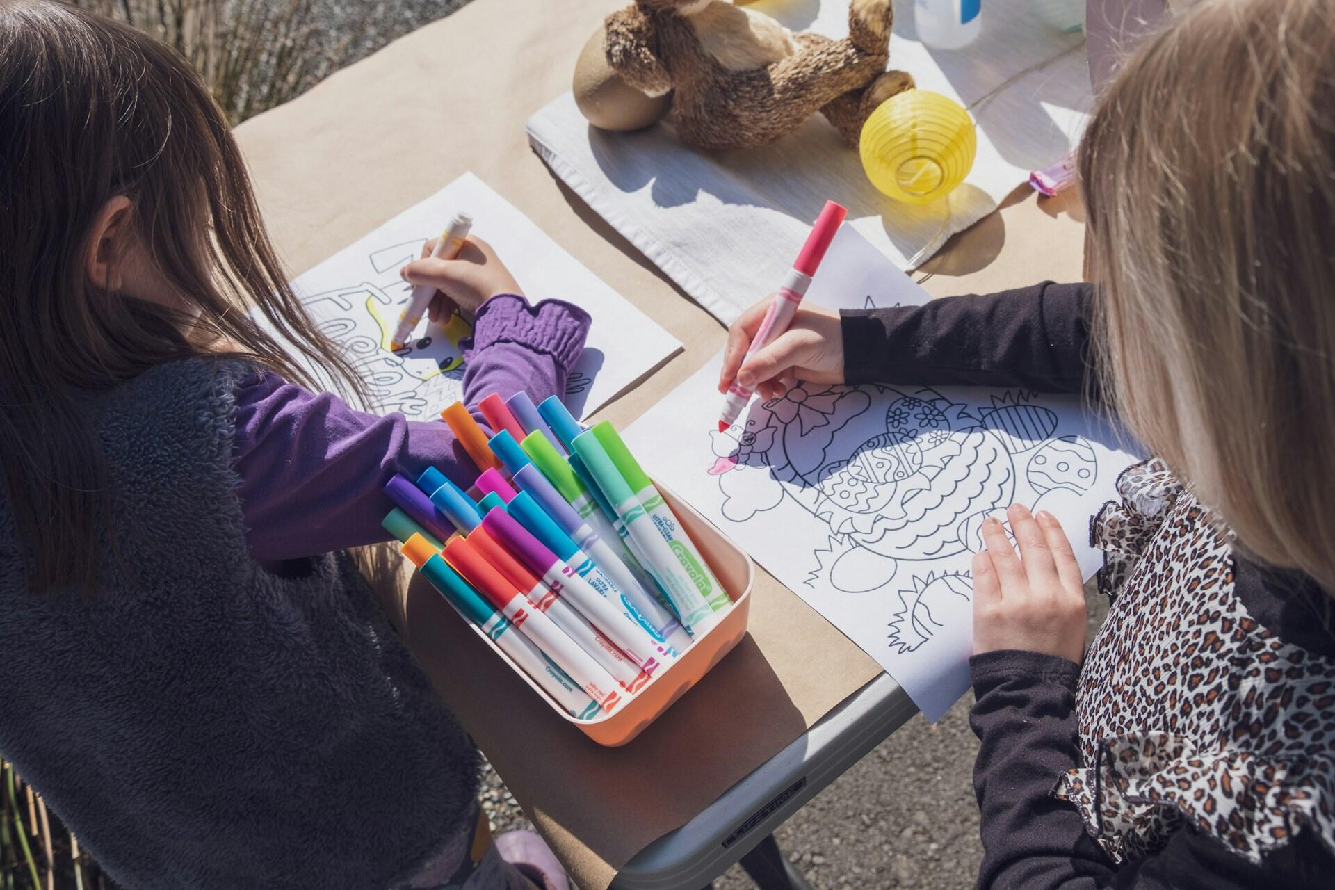 Two young girls drawing designs for Easter.