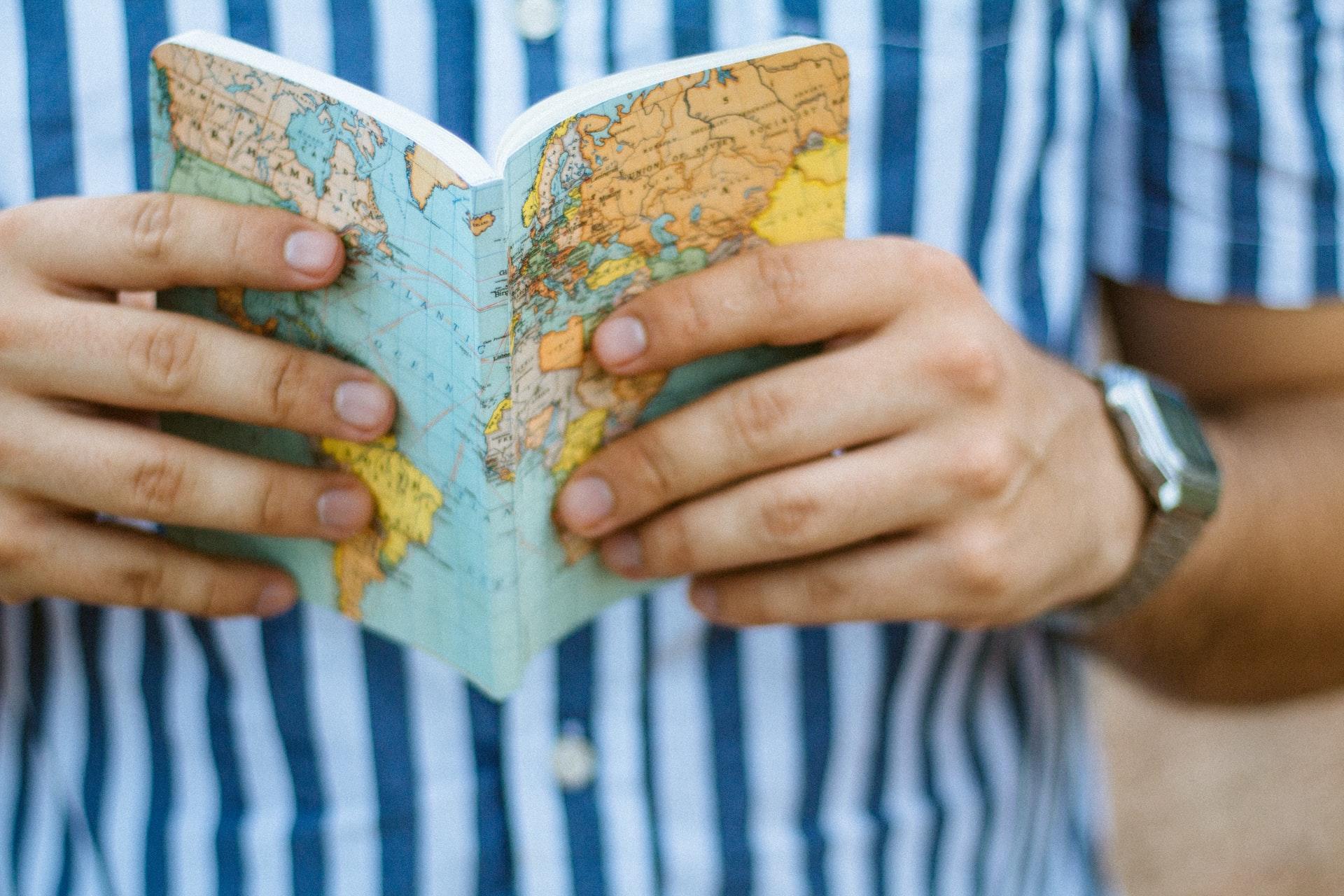 man reads book with map cover
