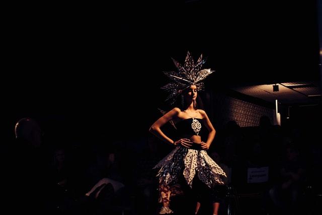 Woman in dance outfit posing in a dark room