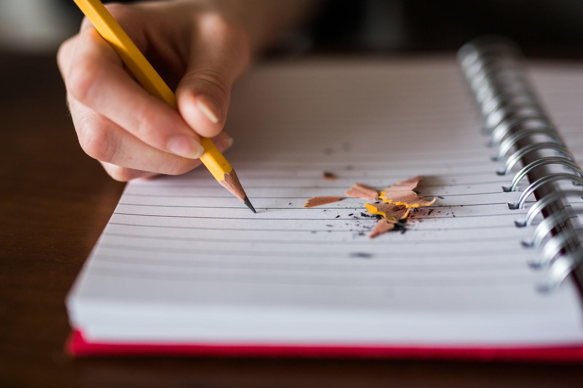 Writing on a Notebook with pencil shaving nearby