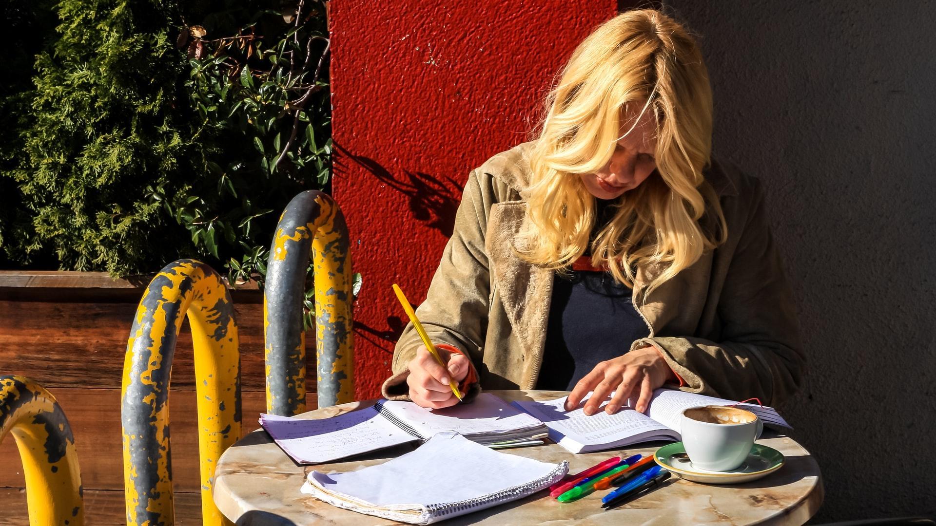 Lady is working on her papers at a cafe
