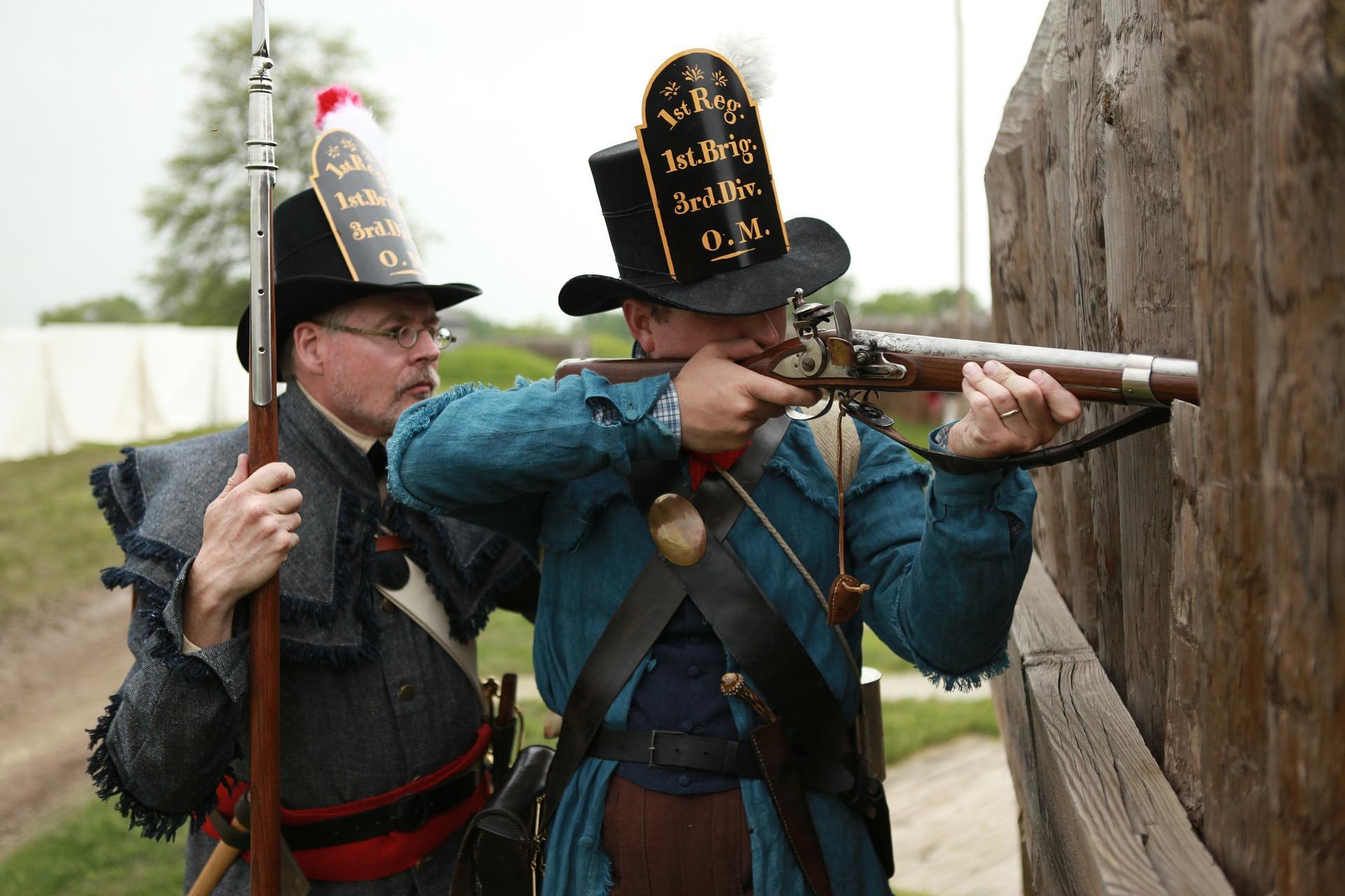 A re-enactment of a Civil War scene from American history with men dressed up in 18th-century attire. War re-enactment is a hobby of many across the States. It spurs national unity, provides a workout, and works as a history lesson