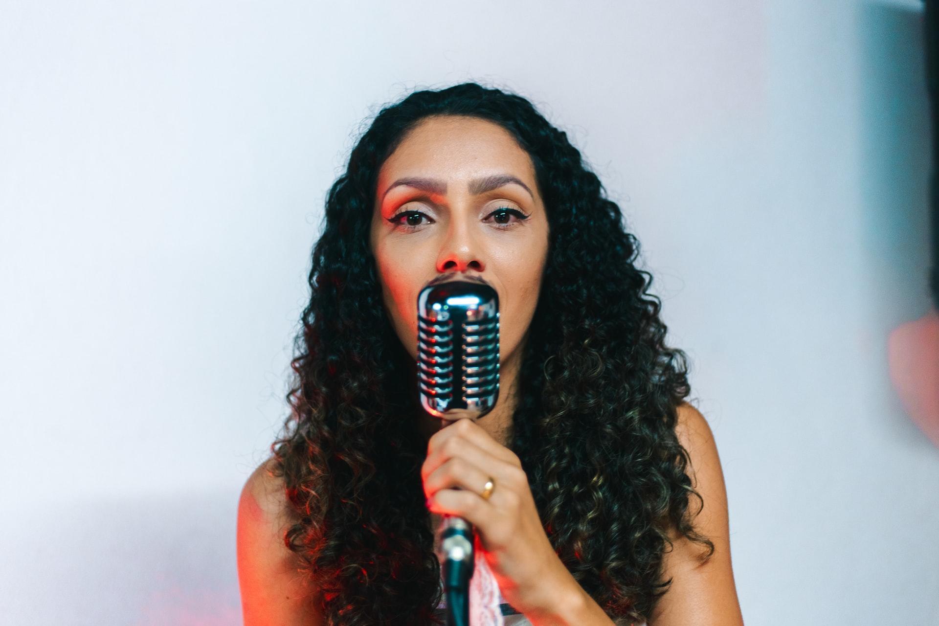 Closeup of women holding microphone singing