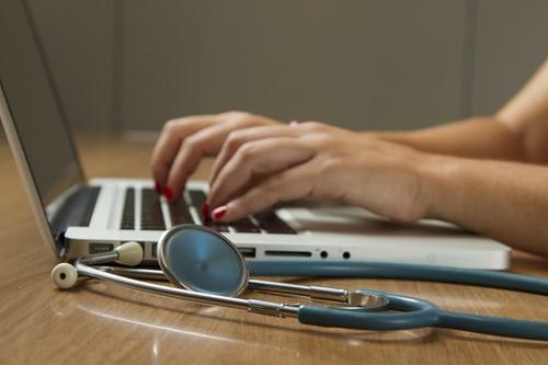 A doctor using her laptop to augment her medical work. Many hospitals tend to use complex computer programming to create software that can help them compile medical records, assign doctors, and schedule appointments