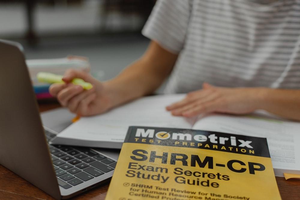 A student in a grey shirt studying with their laptop and study guide lying on the table. You can find many study guides to help you with your English ACT test preparation. However, you may have to enlist the help of a private tutor if the guides aren't enough to get you through