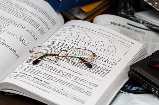 An open book on a table. A laptop and a mouse beside the book, while optical glasses rest on it. Even if your accounting studies begin to get stressful, make sure you get adequate rest, nutrition, and try not to stress yourself out too much!