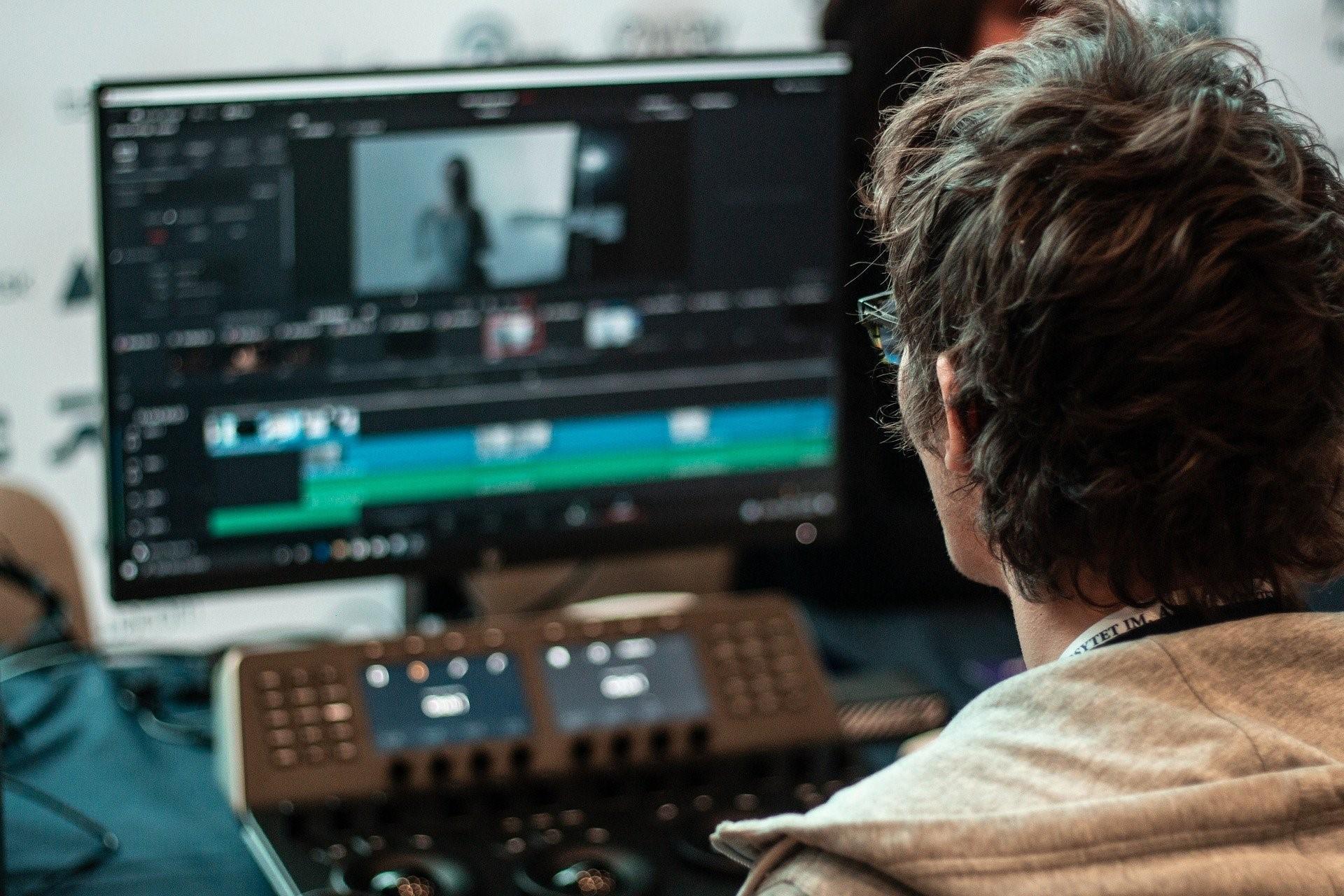 A video editor sitting on a chair and working on Adobe After Effects on his desktop system. Being a freelance designer enables you to choose what time you work, with most millennials choosing to be productive through the night