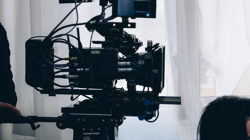 A person using a state-of-the-art video camera for filming. Adobe After Effects can be used to make videos, animations, and motion graphics and has several digital world applications. It is relied on by budding videographers, Hollywood film-makers, and media students alike
