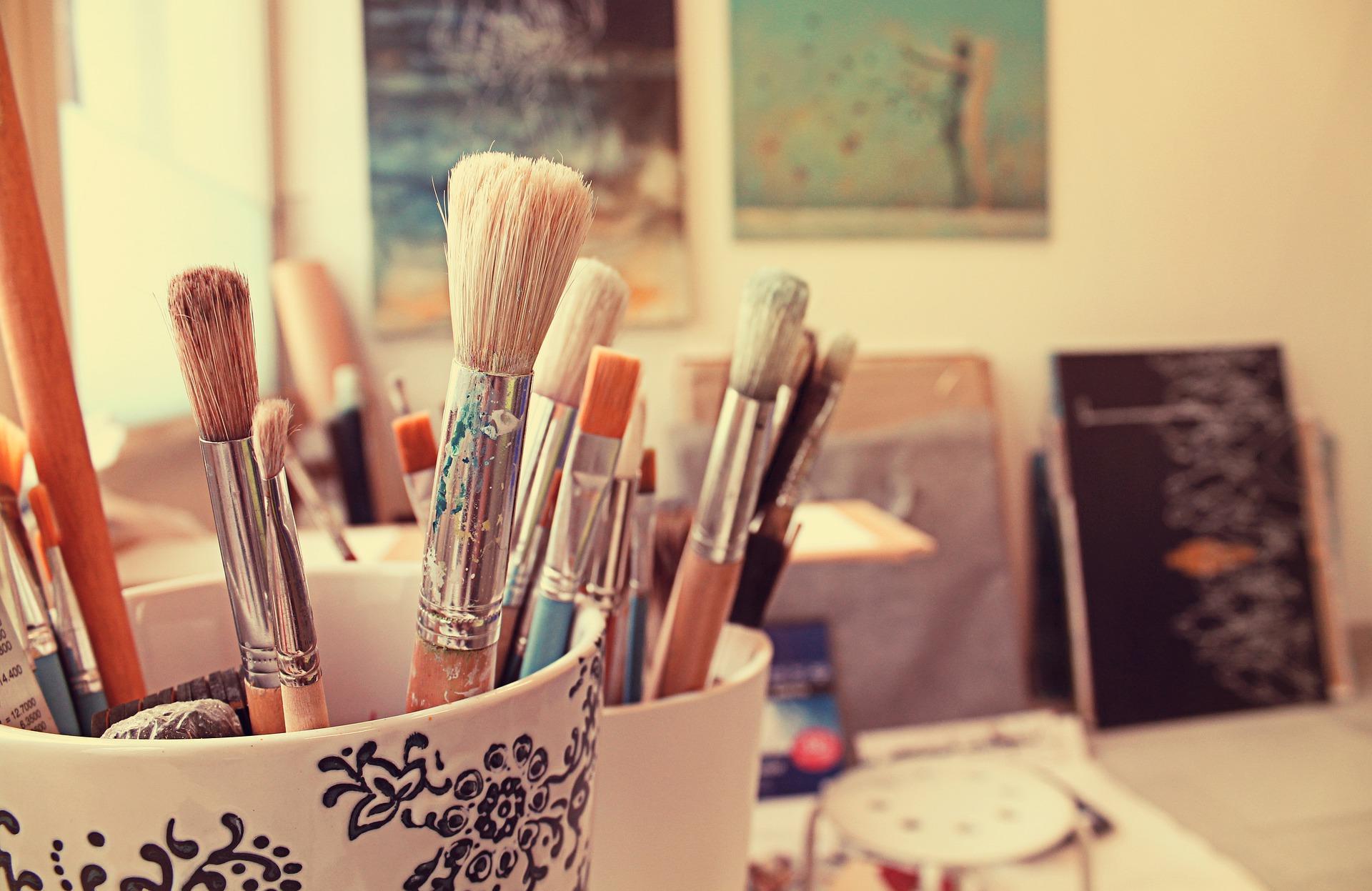 A studio space with paintbrushes and paintings. If you're an artist, you know how important having a peaceful environment is to produce artwork. Fortunately, art schools have some of the best studio spaces for students