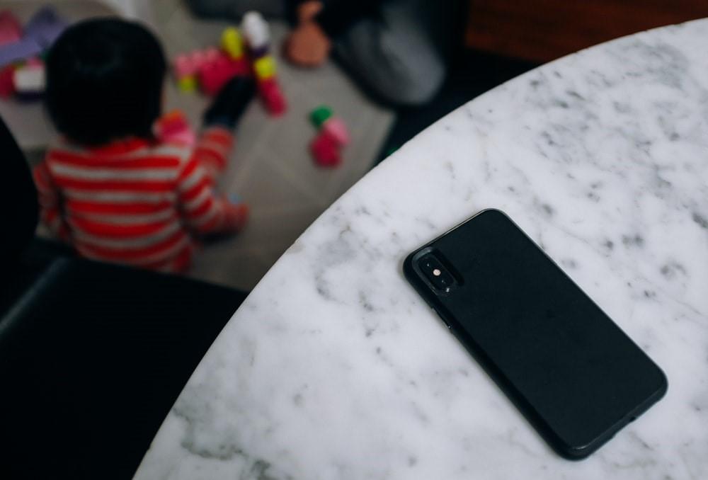 A phone is left on a marble table while a kid plays with toys in front of someone. Babysitting jobs require complete attention; as a babysitter, you cannot leave a child unattended, unhappy, or without adult supervision