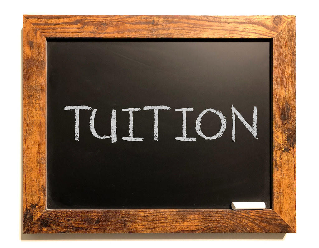 A blackboard with the word 'tuition' writing on it. An advantage of hiring a private computer programming tutor is that their teaching and content plan changes according to your needs