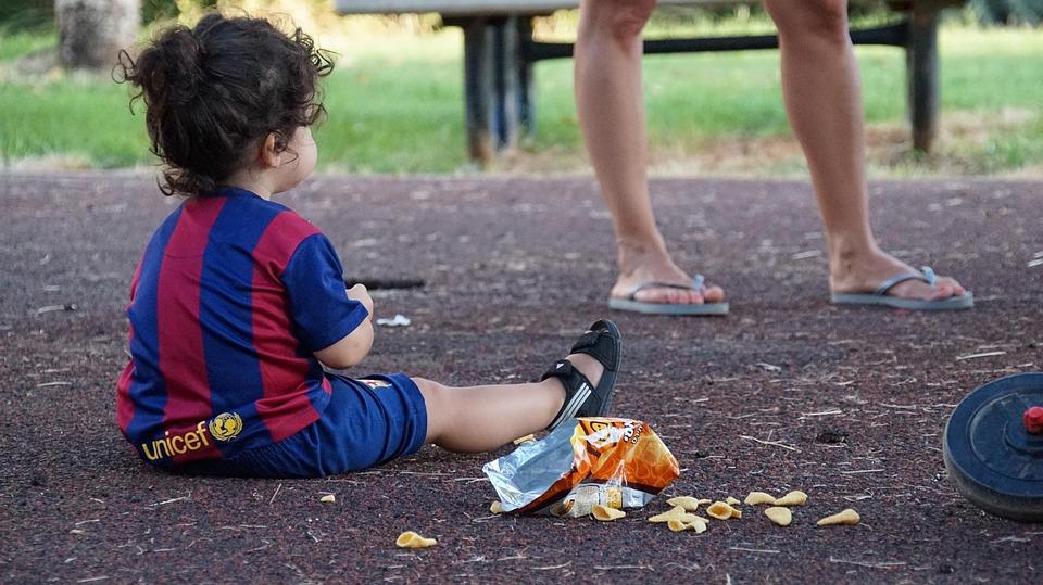 A child sits on the ground, with open snacks spread on the floor, as the babysitter surveys the mess created! Babysitting is a demanding job because you will essentially be answerable for a great chunk of the child's upbringing