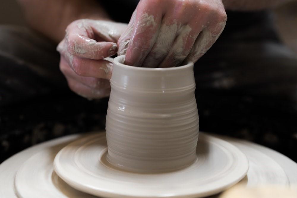 A person sculpting a bowl with their hands on a rotating pottery wheel. The first few weeks of your pottery class will entail learning your way around the pottery wheel. Once you’re adept at it, the real learning begins!