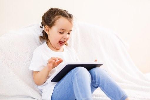 A child practicing coding on her tablet. There are some great coding games for kids that are super fun but also informative!