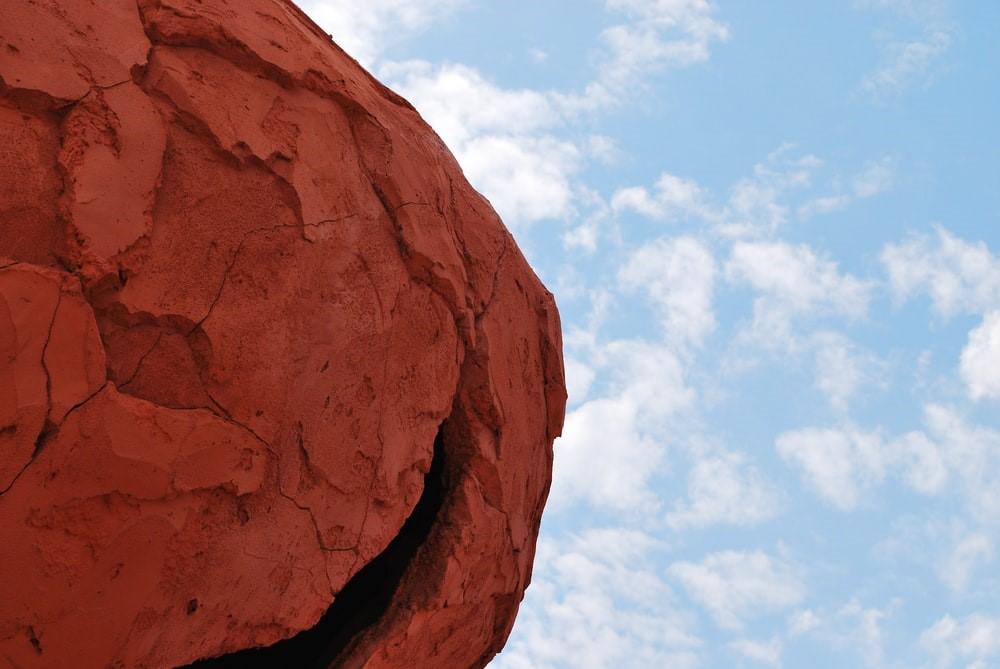 A brown rock formation under the blue sky during the daytime. Many colored clays occur naturally in nature and are sourced directly from rocks and boulders. Some introductory pottery lessons will also educate you regarding the origins of clay