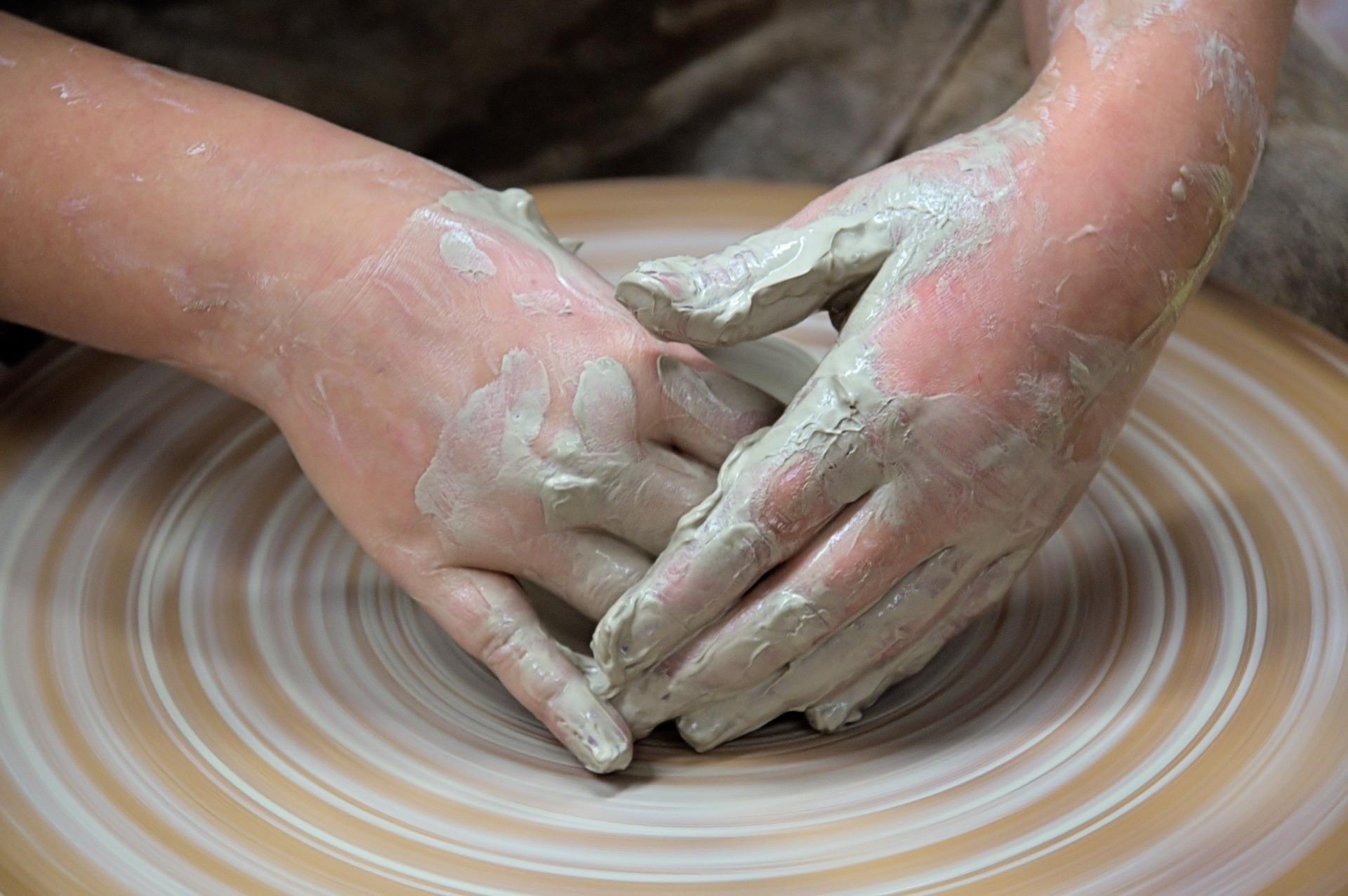 A female student carefully works on her centering on a potter wheel. With the help of an instructor, you'll be able to correct your wrong techniques to make a centered clay