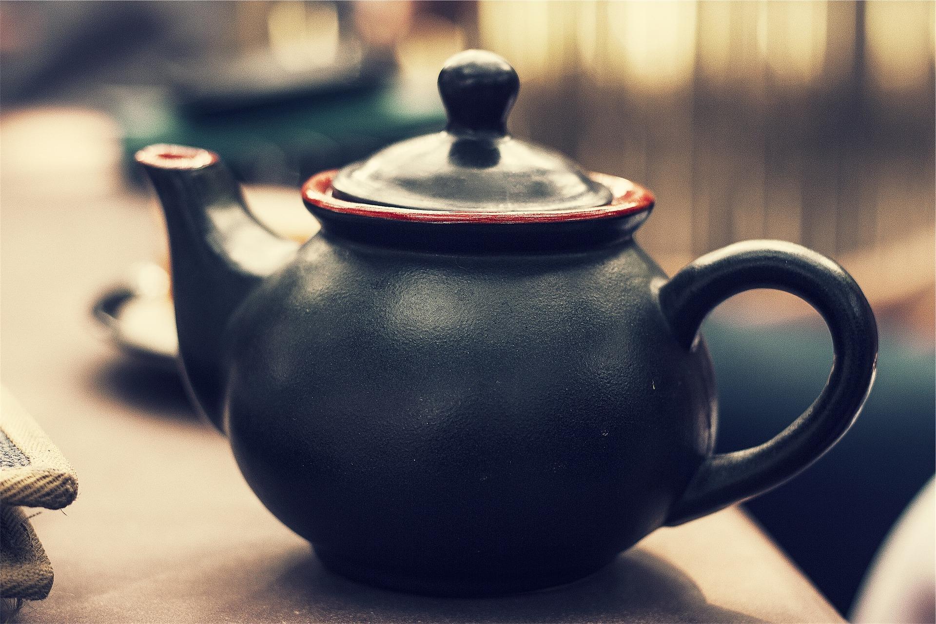 A teapot made using the pottery method is placed at one end of a table. You can make a teapot, cups, flower pot, flower vase, coffee mug, etc. using this versatile art form; throughout history, it was seen as a replacement for wood and metal