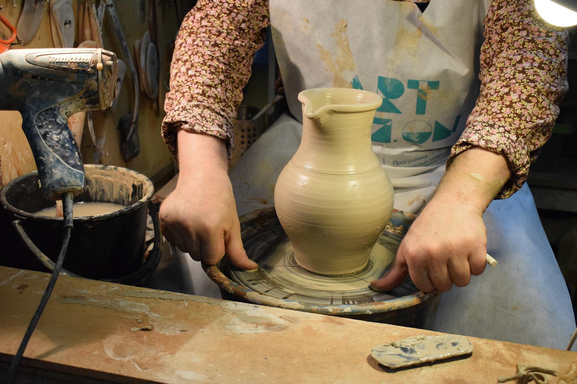 A woman is seen throwing clay on a pottery wheel and carefully working her way out to minimize the imperfections in the final article. Potters who sell their wares usually have years of experience under their belts