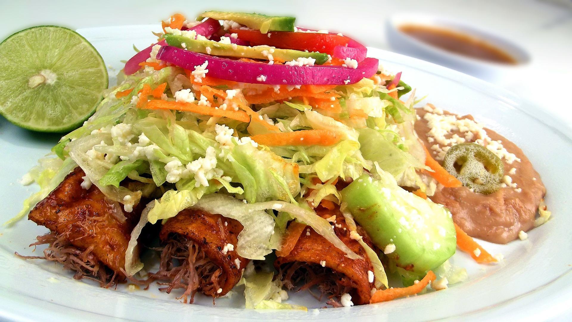 A serving of the famous Mexican dish Enchilada. Popular Mexican dishes such as enchiladas, burritos, and tacos have become an essential part of Mexican pop culture and are a great representation of Mexican ingredients