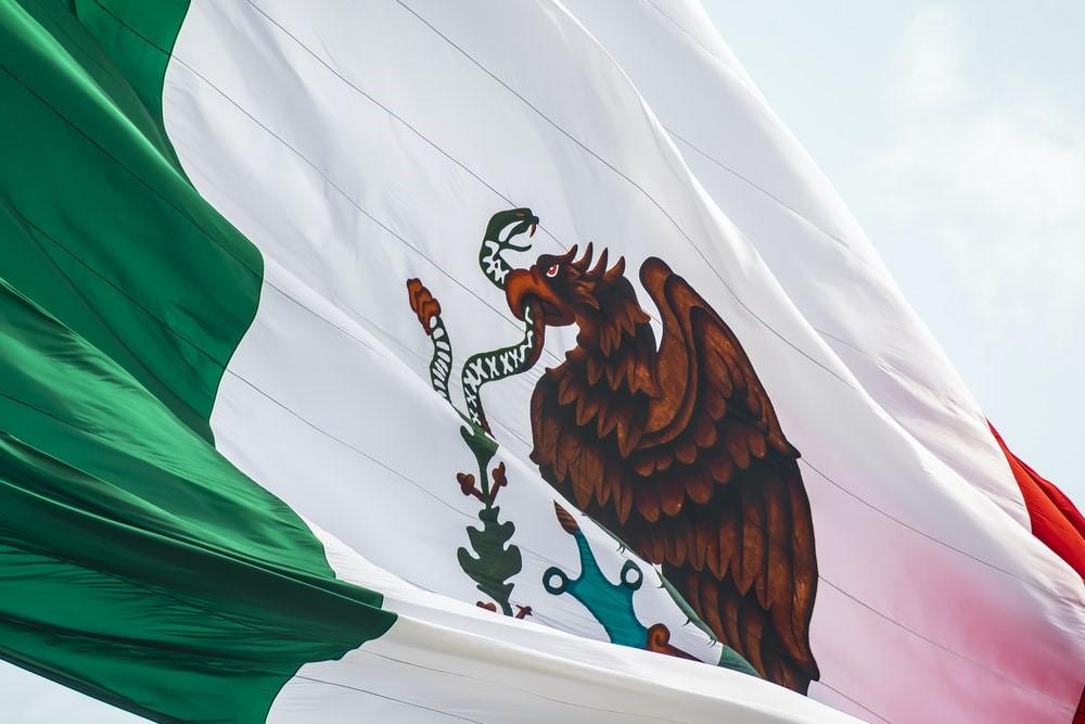 The flag of Mexico displays stripes of green, white and red, and an eagle emblem. The Mexican flag is a depiction of its natural flora and fauna and its rich history. Although Hollywood depicts the country as barren and arid, Mexican movies are a more authentic representation