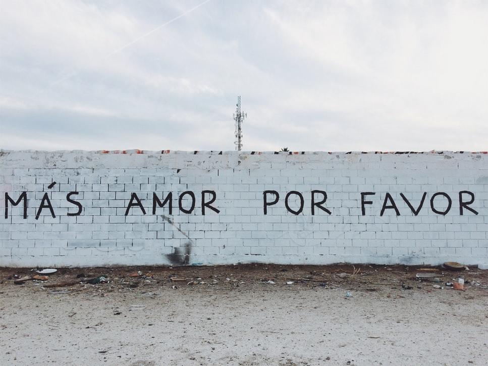 A wall in Mexico with the words Más Amor, Por Favor written on it. This translates to more love, please. By studying Spanish in Mexico, you will be able to read what is written on any banners, signs or walls that walk past.