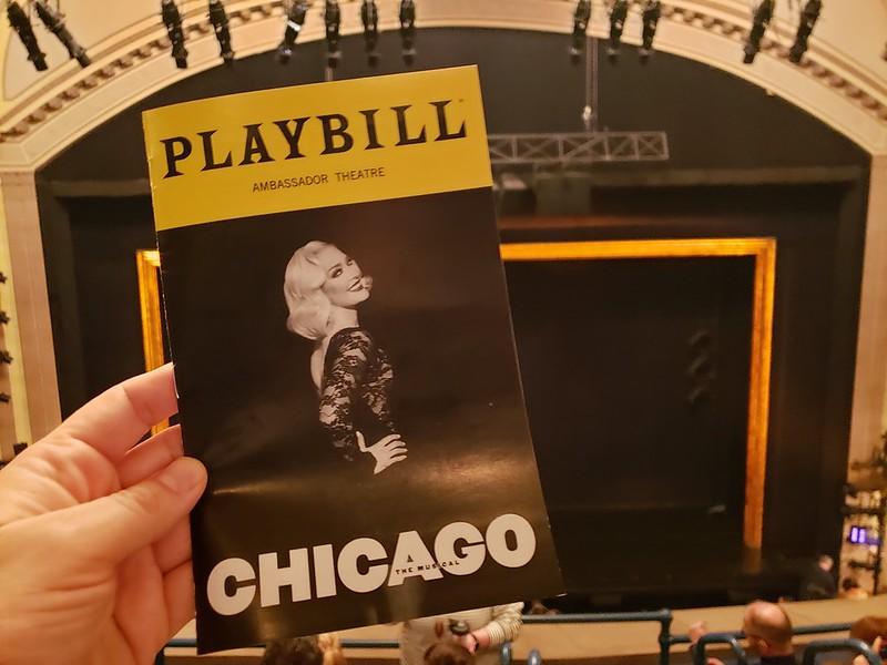 A person is holding the playbill for Chicago at the famed Ambassador Theatre. The playbill is a way to notify the audience of the proceedings of the play when they settle in to watch it. Each show on Broadway, New York City, provides patrons with a specialized playbill.
