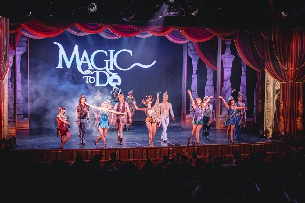 A theatrical group dressed in medieval folk costumes dancing on stage while the audience cheers them on. Many of the top Broadway shows have budgets rivaling and at times exceeding many small-tier movies!