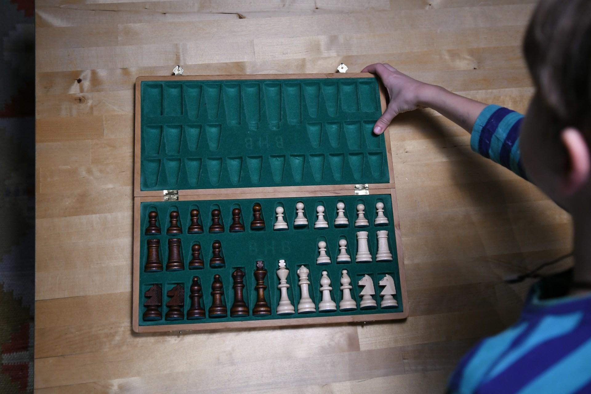A child opening a chess set.