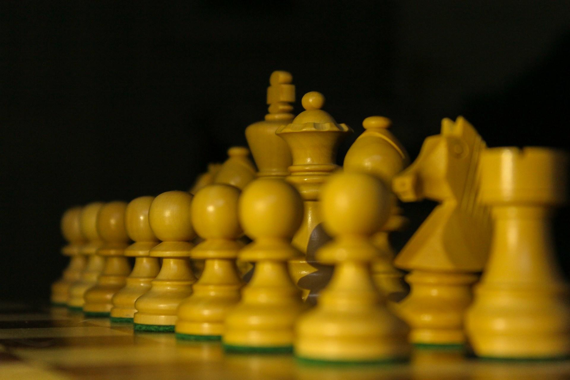 Yellow chess pieces at the start of the game.