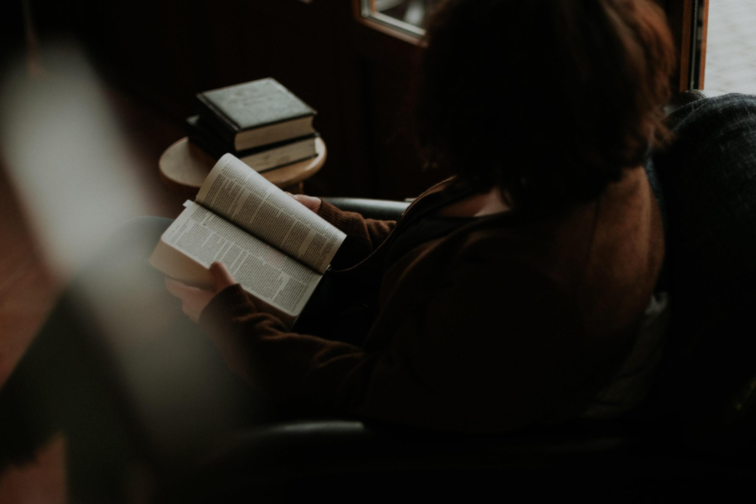 A French learner reads a French book while sitting on the sofa