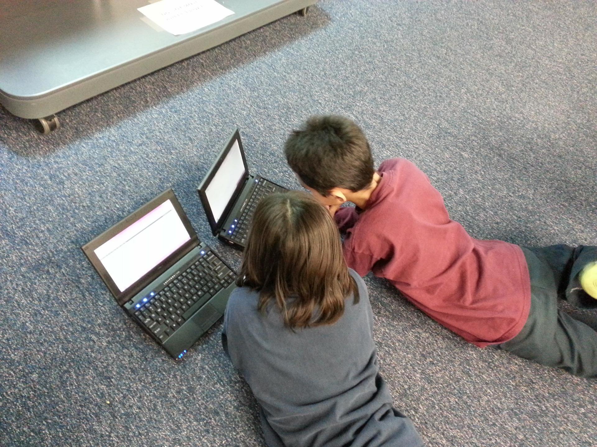 A grade 6 boy and girl keenly learn their middle school math using math apps on their computers