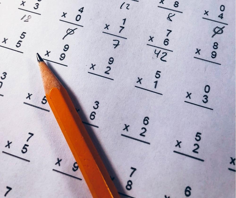 A pencil over a paper with numerous multiplication questions on it. It reminds us how much we used to practice maths. To get good grades in middle school math or any level, we’d still need to practice more and more