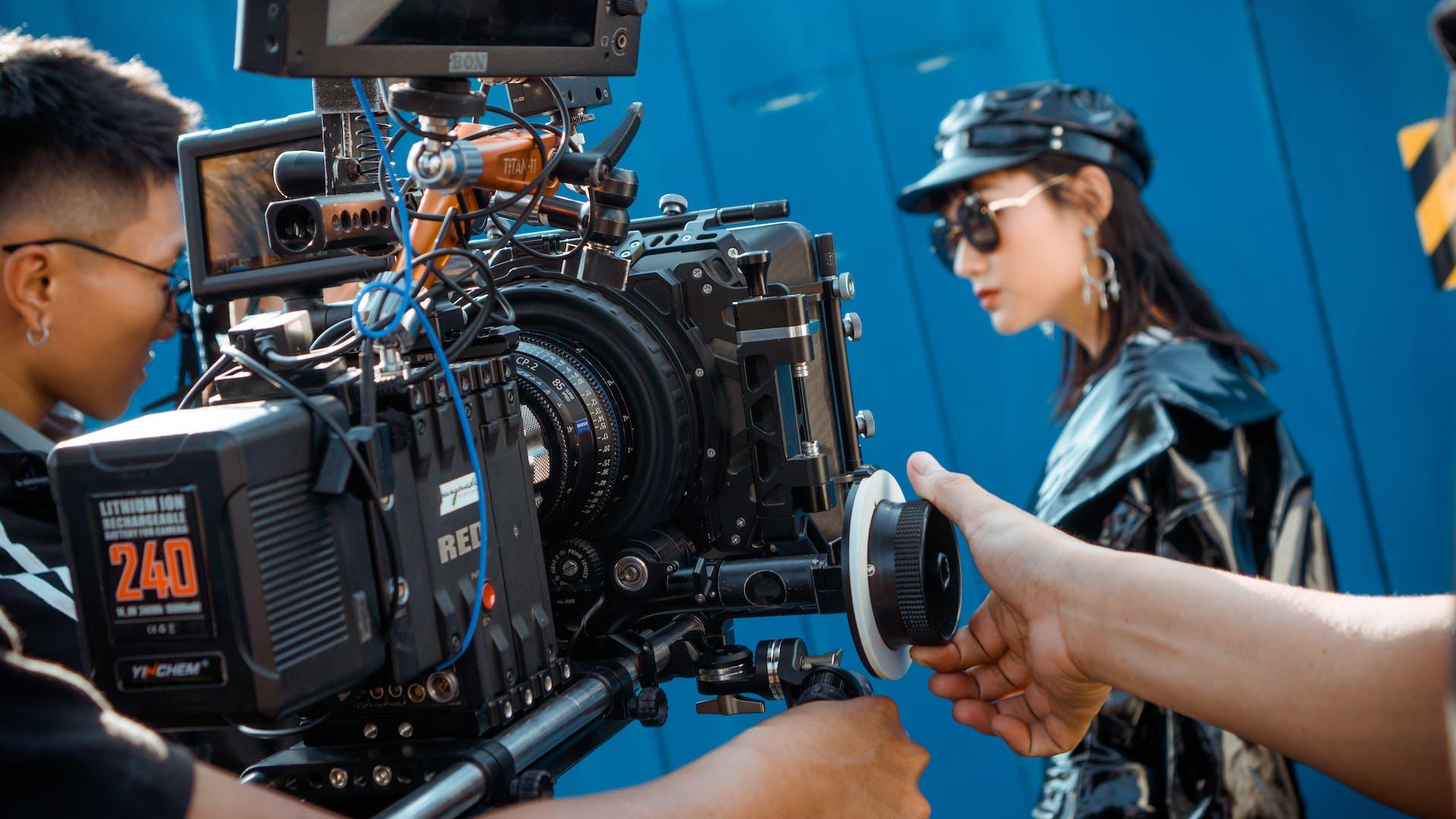 A filming camera crew films an actress outdoors