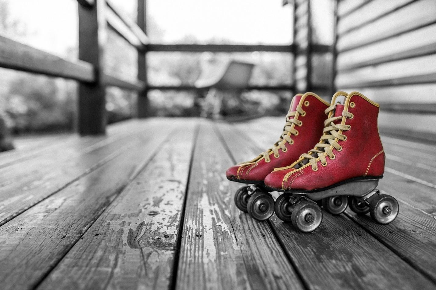 A pair of skates lie on the patio, waiting to be worn