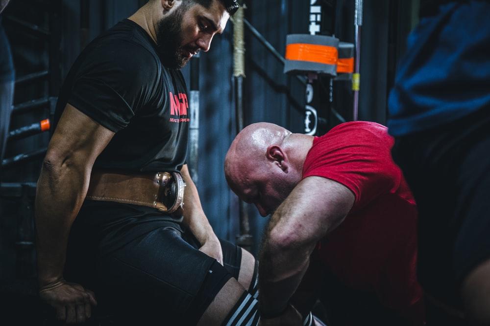 A trainer preparing their client to begin lifting