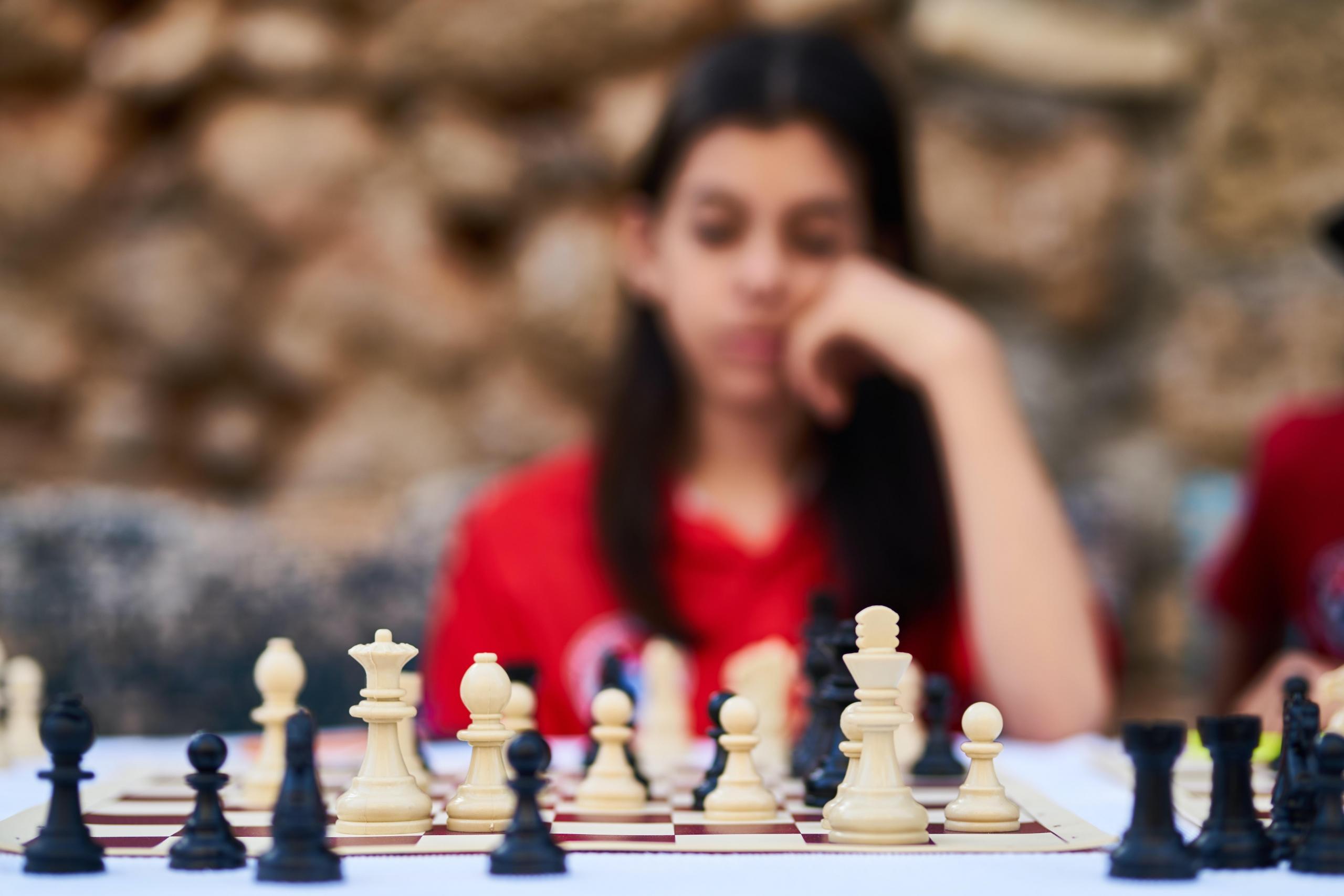 A girl staring at a chess board