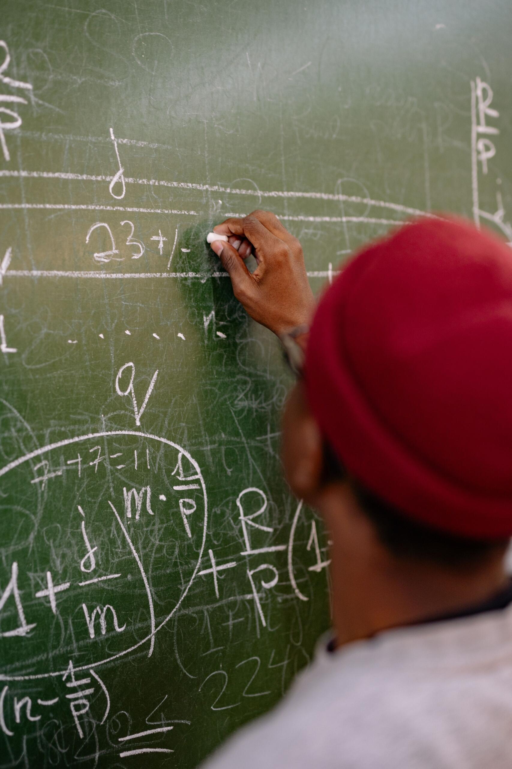 A student is working out a solution on the class blackboard
