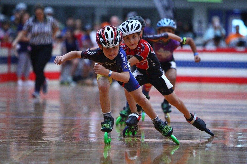 A group of children roller-blading inside a skating rink