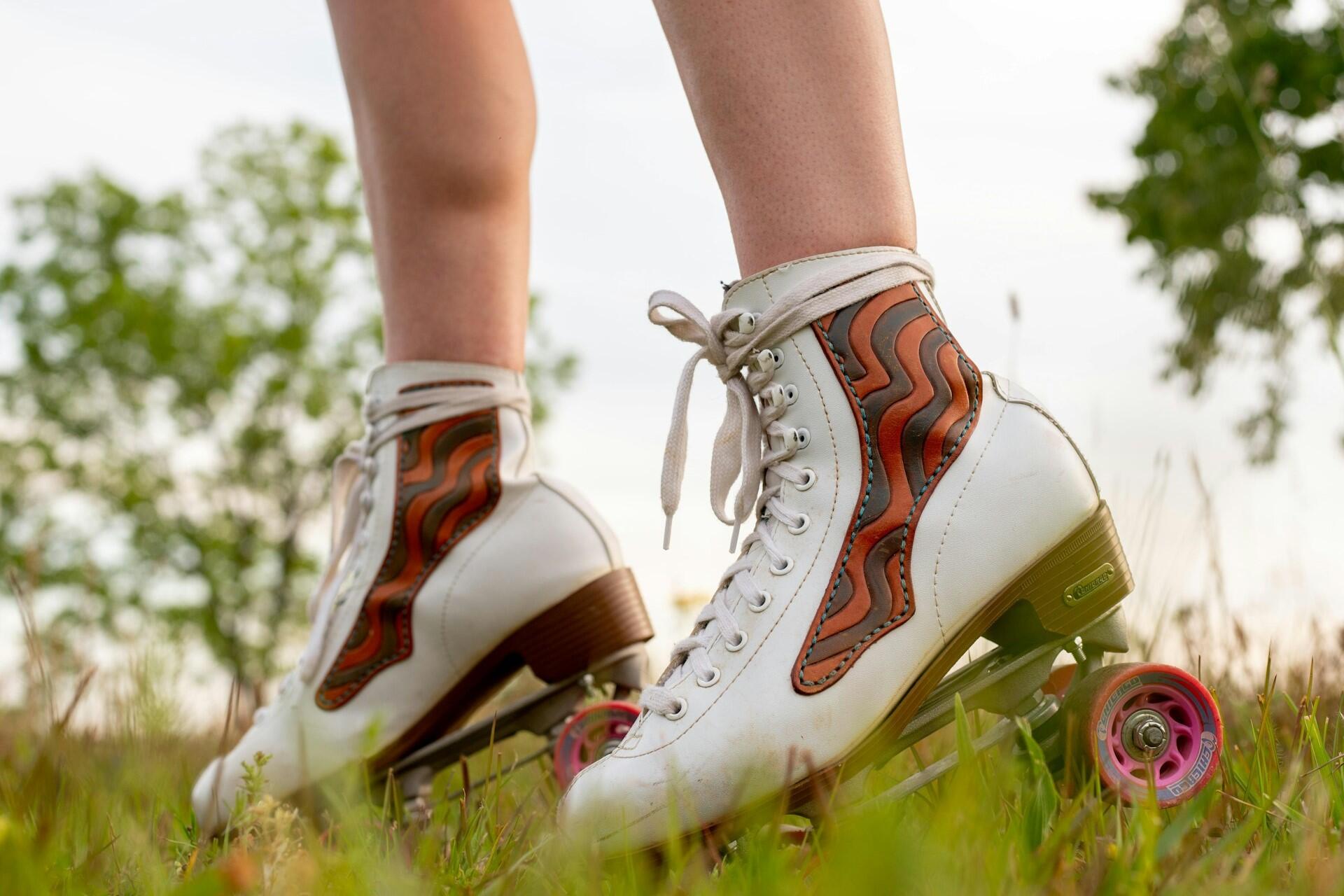 White quad roller skates with pink wheels on grass