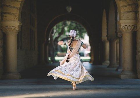 A woman wearing Indian attire dancing in a temple