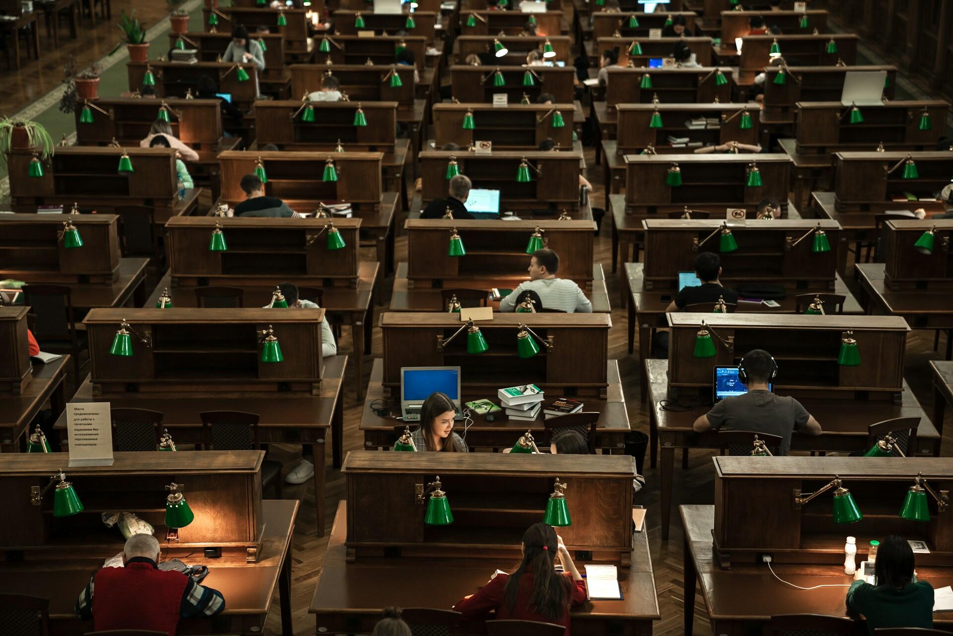 college students studying at cubicles in a large library